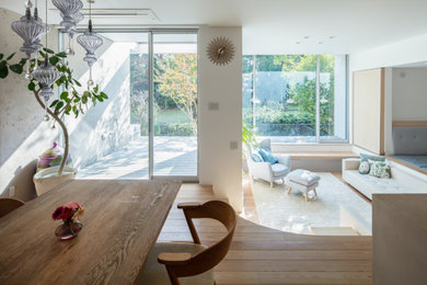 Modelo de salón abierto de estilo zen con paredes blancas y suelo de madera clara