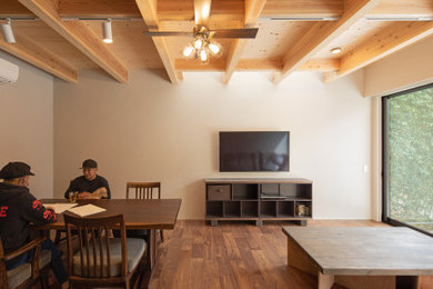 Imagen de salón minimalista pequeño con paredes grises, suelo de contrachapado, suelo marrón y televisor colgado en la pared