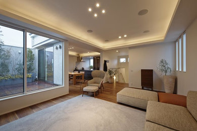 Diseño de salón contemporáneo con paredes blancas, suelo de madera en tonos medios y suelo marrón