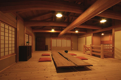 Imagen de salón asiático con paredes marrones, suelo de madera en tonos medios y suelo marrón