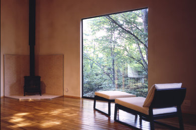 Foto de salón abierto nórdico de tamaño medio con paredes beige, suelo de madera en tonos medios, todas las chimeneas, marco de chimenea de piedra, suelo beige y madera