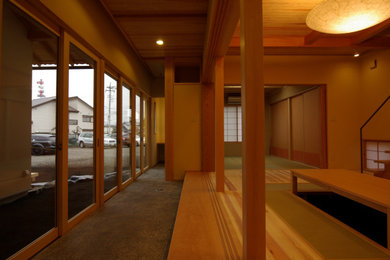 Ejemplo de salón para visitas abierto de estilo zen de tamaño medio con paredes beige, suelo de madera clara y televisor independiente