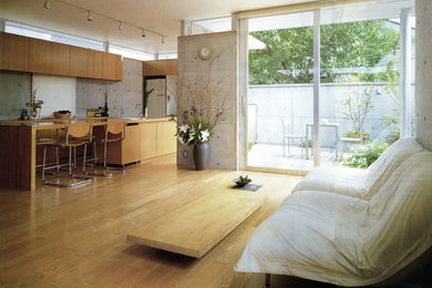 Modelo de salón abierto urbano de tamaño medio con paredes grises, suelo de madera clara y suelo beige