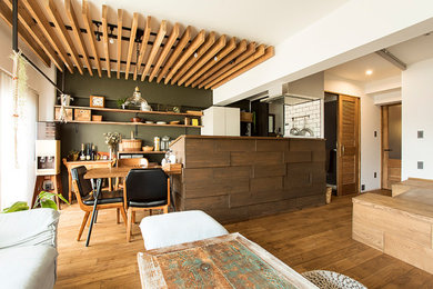 Foto de salón con barra de bar abierto rural de tamaño medio sin chimenea con paredes grises, suelo de madera en tonos medios, televisor colgado en la pared y suelo marrón