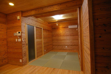 Foto de salón con barra de bar de estilo zen de tamaño medio sin chimenea con paredes marrones, suelo de madera en tonos medios y suelo beige