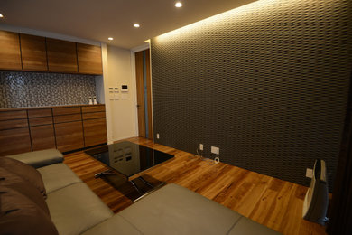 Diseño de salón abierto y blanco minimalista grande con paredes negras, suelo de contrachapado, suelo marrón y televisor independiente