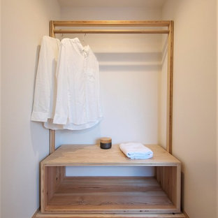Modelo de armario vestidor unisex, asiático, pequeño, con suelo de madera en tonos medios, suelo marrón, armarios abiertos y puertas de armario beige