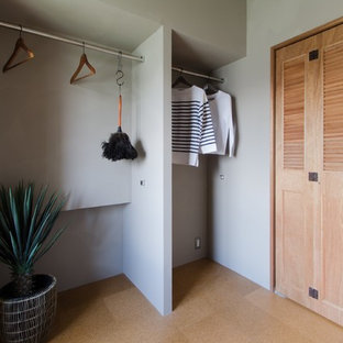 Ispirazione per una cabina armadio unisex etnica di medie dimensioni con ante a persiana e pavimento in sughero