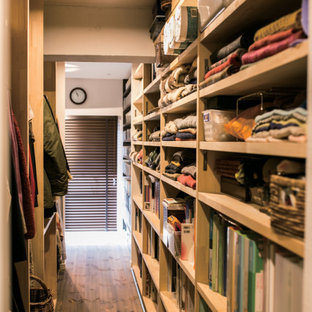 Esempio di una cabina armadio unisex industriale con parquet scuro e soffitto in carta da parati