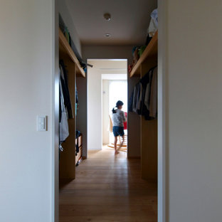 Inredning av ett retro stort walk-in-closet för könsneutrala, med öppna hyllor, mellanmörkt trägolv och brunt golv