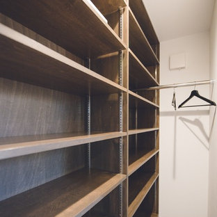 Imagen de armario vestidor unisex, escandinavo, de tamaño medio, con armarios abiertos, puertas de armario de madera en tonos medios y suelo de baldosas de cerámica