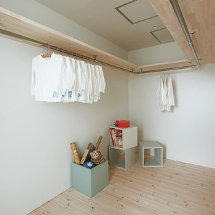 Imagen de armario vestidor nórdico con suelo de madera clara y suelo beige