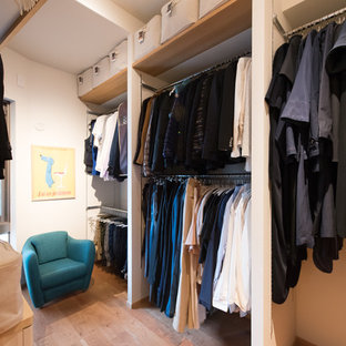 Diseño de armario y vestidor de estilo zen con suelo de madera en tonos medios
