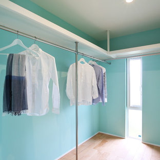 Diseño de armario vestidor unisex, minimalista, pequeño, con suelo de madera clara y suelo beige
