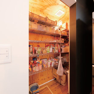 Immagine di una cabina armadio industriale di medie dimensioni con nessun'anta, ante grigie, pavimento in legno massello medio e pavimento marrone