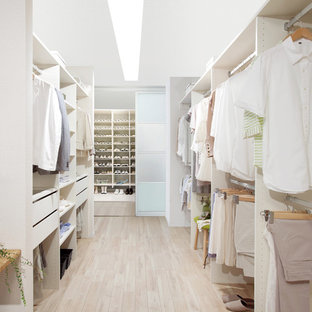 Diseño de armario vestidor unisex, escandinavo, grande, con armarios abiertos, puertas de armario blancas, suelo de madera clara y suelo beige