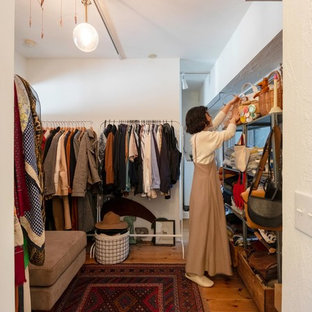 Modelo de vestidor unisex, asiático, con armarios abiertos, suelo de madera en tonos medios y suelo marrón