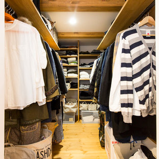 Inspiration pour un dressing urbain avec un sol en bois brun, un placard sans porte et un sol marron.