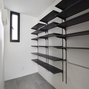 Esempio di una cabina armadio unisex moderna con nessun'anta, ante nere, pavimento in gres porcellanato e pavimento grigio