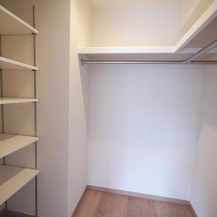 Ispirazione per una cabina armadio nordica con ante bianche, pavimento in compensato e pavimento beige
