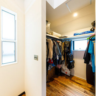 Cette image montre un dressing minimaliste avec un sol en bois brun et un sol rose.