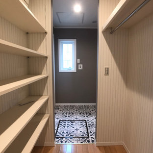 Ejemplo de armario vestidor unisex y papel pintado, nórdico, grande, con armarios abiertos, suelo de madera clara, suelo beige y papel pintado