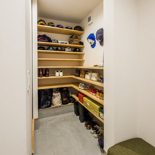 Ejemplo de armario vestidor unisex, minimalista, con armarios abiertos, suelo de cemento, suelo gris y puertas de armario de madera oscura