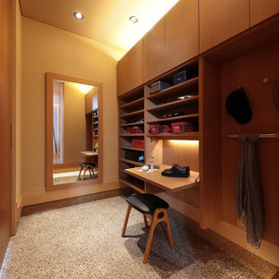 Ispirazione per una cabina armadio minimal con ante marroni, pavimento grigio e pavimento in cemento