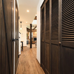 Imagen de armario unisex, de estilo zen, grande, con armarios con puertas mallorquinas, puertas de armario marrones, suelo de madera en tonos medios y suelo marrón