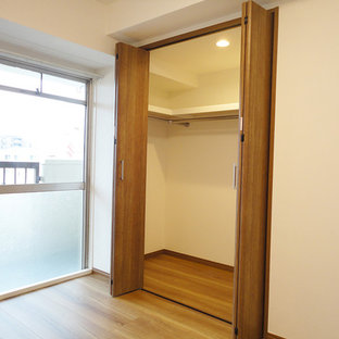 Immagine di armadi e cabine armadio nordici con ante in legno scuro, pavimento in compensato e pavimento marrone
