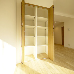 Foto di un armadio o armadio a muro nordico con ante in legno scuro, pavimento in compensato, pavimento beige e soffitto in carta da parati