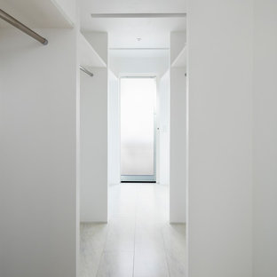 Immagine di una cabina armadio shabby-chic style con pavimento in laminato e pavimento bianco