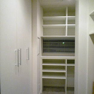 Modelo de armario vestidor moderno, pequeño, con puertas de armario blancas y suelo de piedra caliza