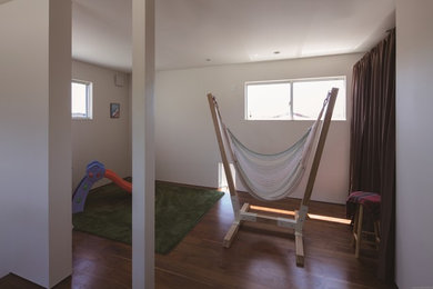 Idee per una cameretta per bambini da 4 a 10 anni minimalista di medie dimensioni con pareti bianche, parquet scuro e pavimento marrone