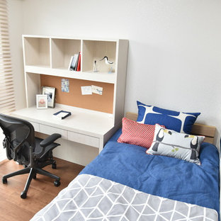 Idéer för att renovera ett mellanstort nordiskt barnrum kombinerat med skrivbord, med vita väggar, plywoodgolv och brunt golv