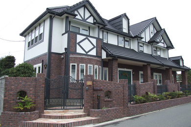 Ejemplo de fachada de casa marrón tradicional con tejado a dos aguas
