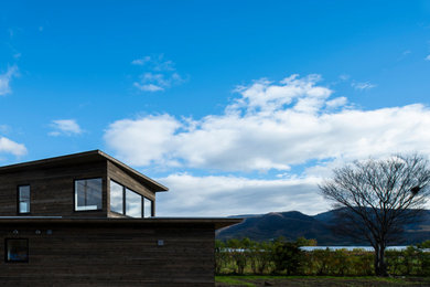 Imagen de fachada de casa de dos plantas con revestimiento de madera y tejado plano