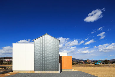 Diseño de fachada de casa gris de tamaño medio de una planta con revestimientos combinados, tejado a dos aguas y tejado de metal