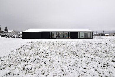 Modelo de fachada negra minimalista de una planta con tejado de un solo tendido
