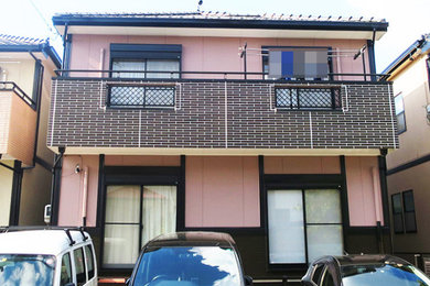 名古屋にあるおしゃれな家の外観 (ピンクの外壁) の写真