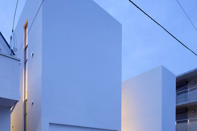 Imagen de fachada de casa blanca contemporánea de tres plantas con revestimiento de hormigón y tejado plano