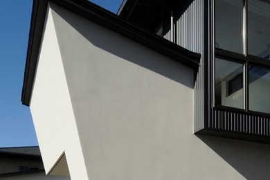 Diseño de fachada de casa blanca minimalista de dos plantas con tejado a la holandesa y tejado de metal