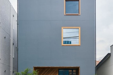 Immagine della facciata di una casa piccola grigia moderna