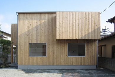 Modelo de fachada de casa de estilo zen pequeña de dos plantas con revestimiento de madera y tejado de metal
