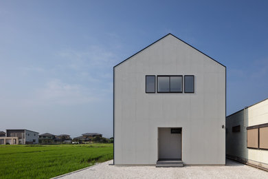 Modelo de fachada de casa gris moderna de tamaño medio de dos plantas con revestimientos combinados, tejado a dos aguas y tejado de metal