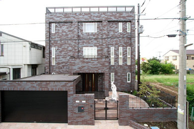 Imagen de fachada de casa marrón moderna de tres plantas con tejado plano