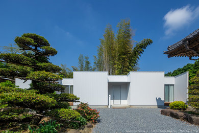 Diseño de fachada de casa blanca de tamaño medio de una planta con revestimientos combinados, tejado de un solo tendido y tejado de metal