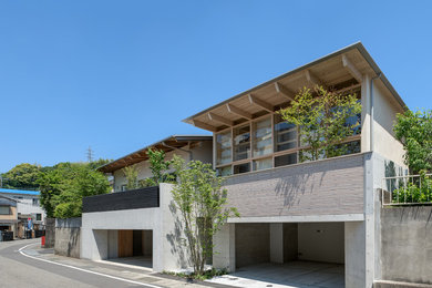 Idée de décoration pour une façade de maison asiatique de taille moyenne et à niveaux décalés avec un toit en métal.