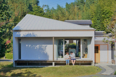 Foto de fachada blanca minimalista de dos plantas con revestimiento de metal y tejado a cuatro aguas