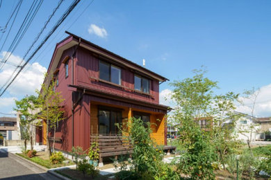 Imagen de fachada de casa roja y roja de estilo americano de dos plantas con revestimiento de madera, tejado a dos aguas, tejado de metal y tablilla